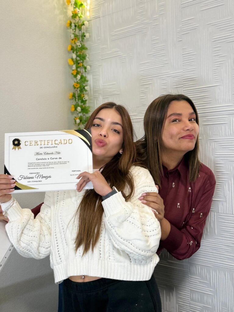 Duas alunas a mostrar um certificado de formação