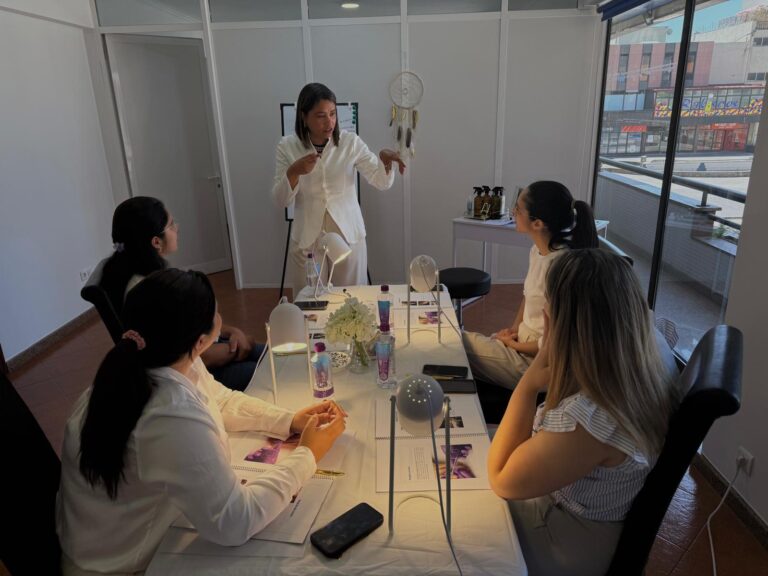 Formadora a ensinar numa sala luminosa, com alunas sentadas à mesa
