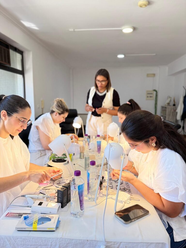 Sala de aula cheia, com a formadora ao fundo e alunas a trabalhar