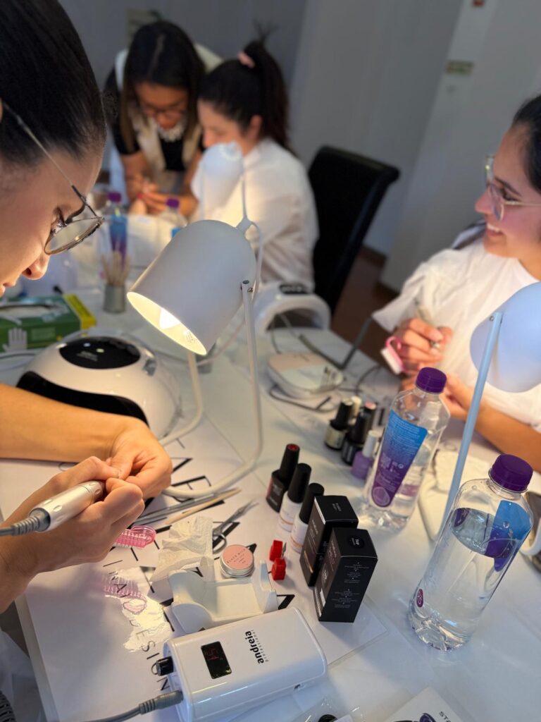 Alunas a trabalhar nas unhas com lâmpada LED e material profissional