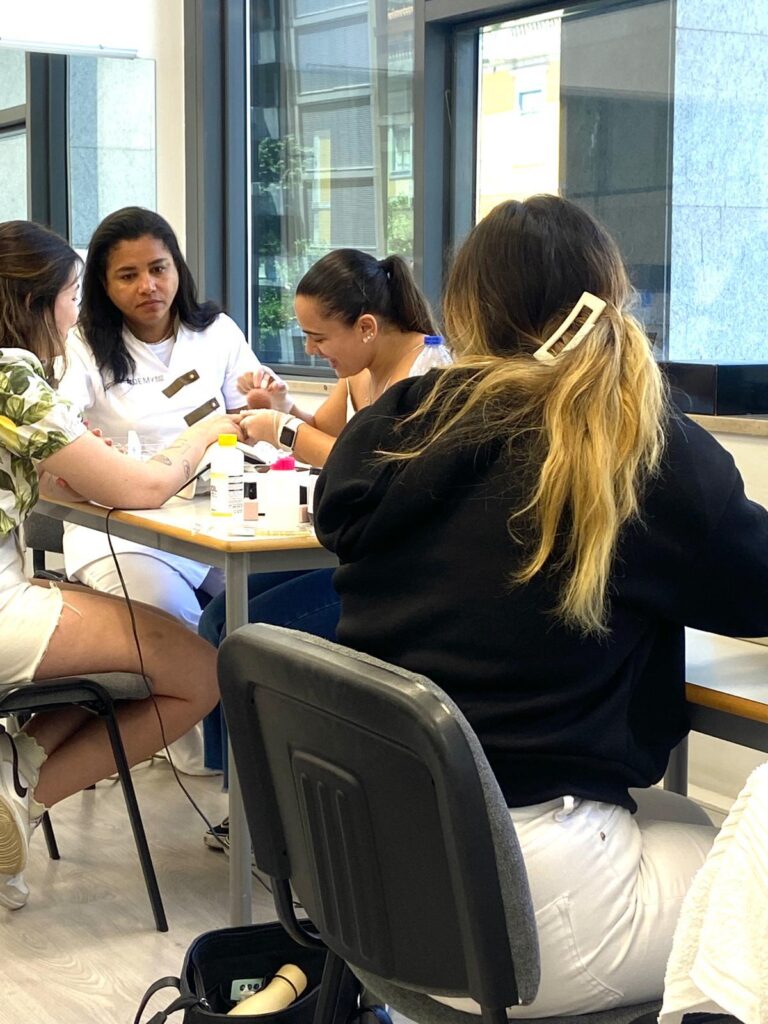 Alunas a trabalhar em grupo numa mesa, junto à janela