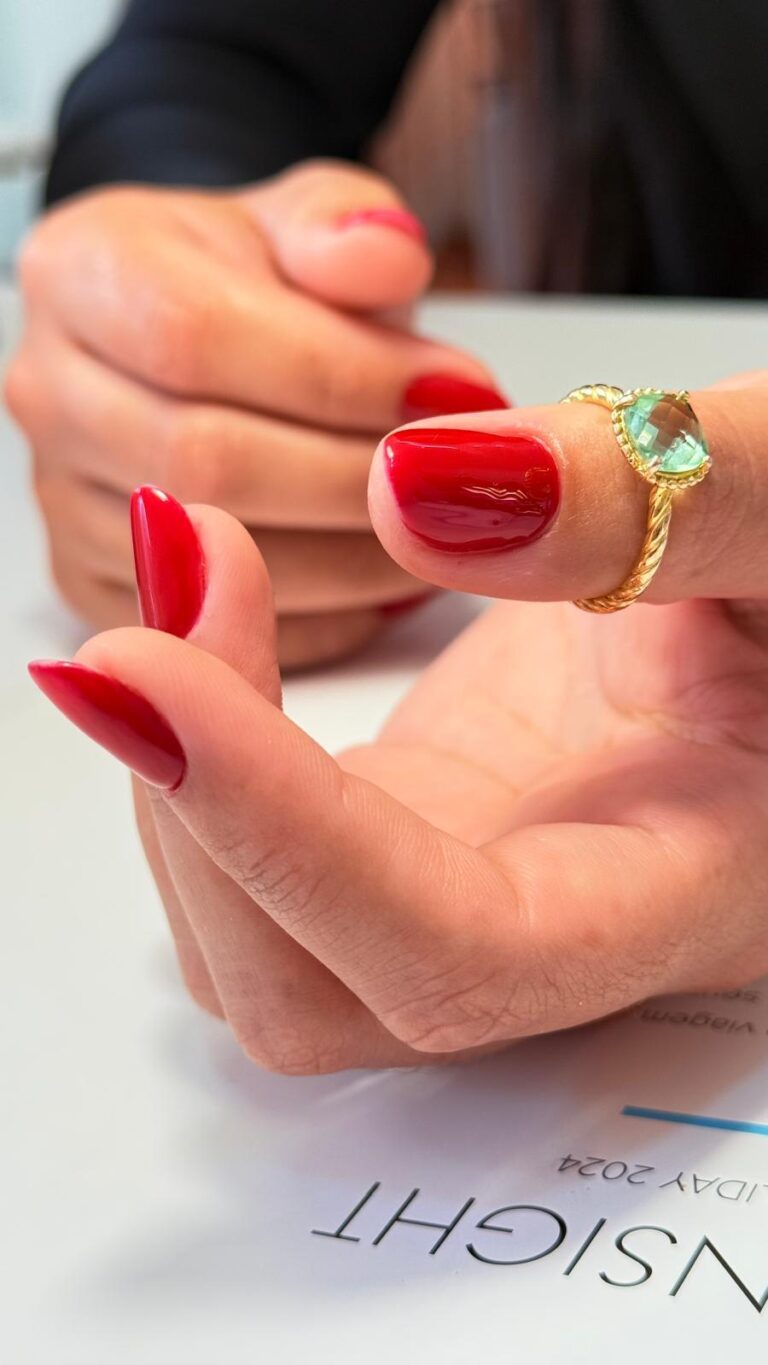 Unhas vermelhas em amêndoa, com um anel