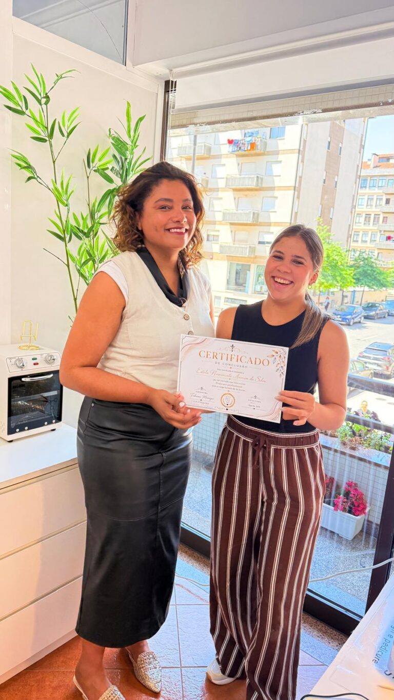 Duas alunas com o certificado, junto à janela