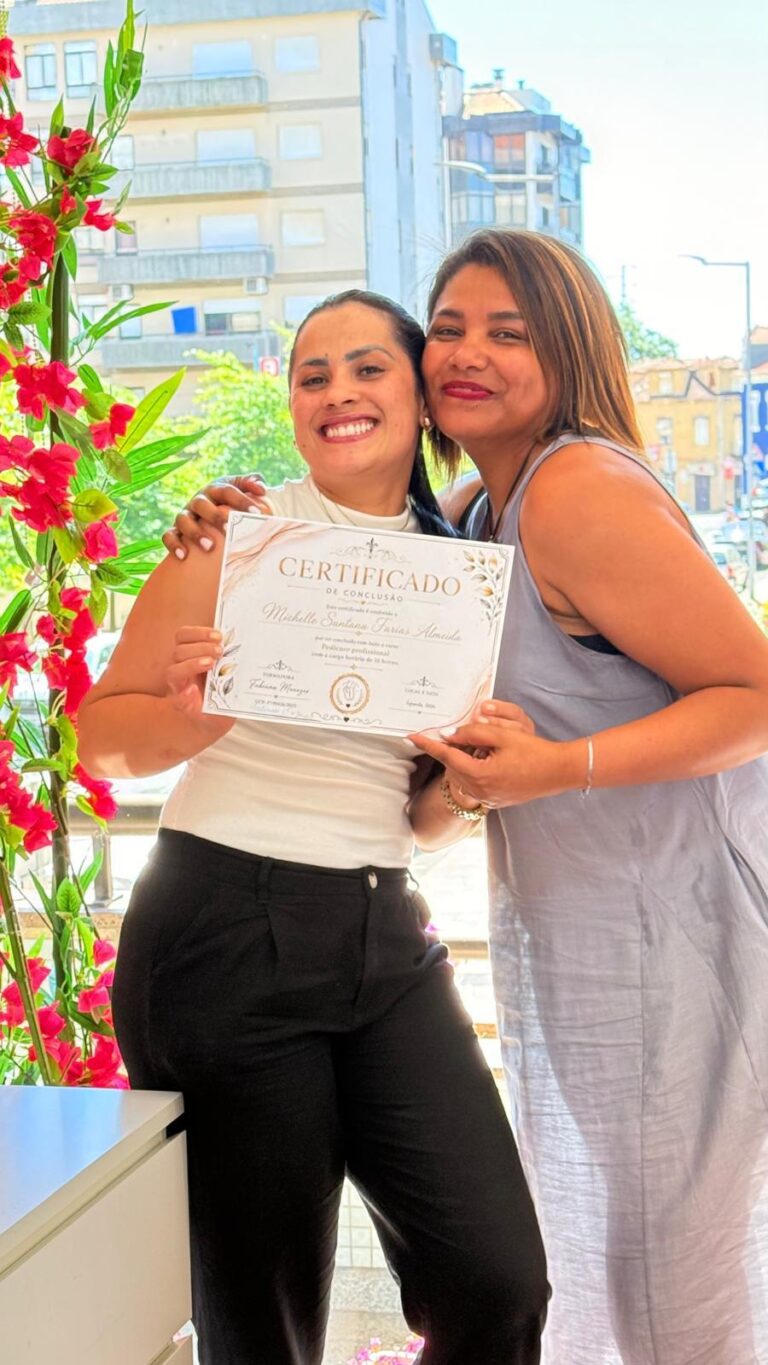 Aluna e formadora abraçadas, a mostrar o certificado